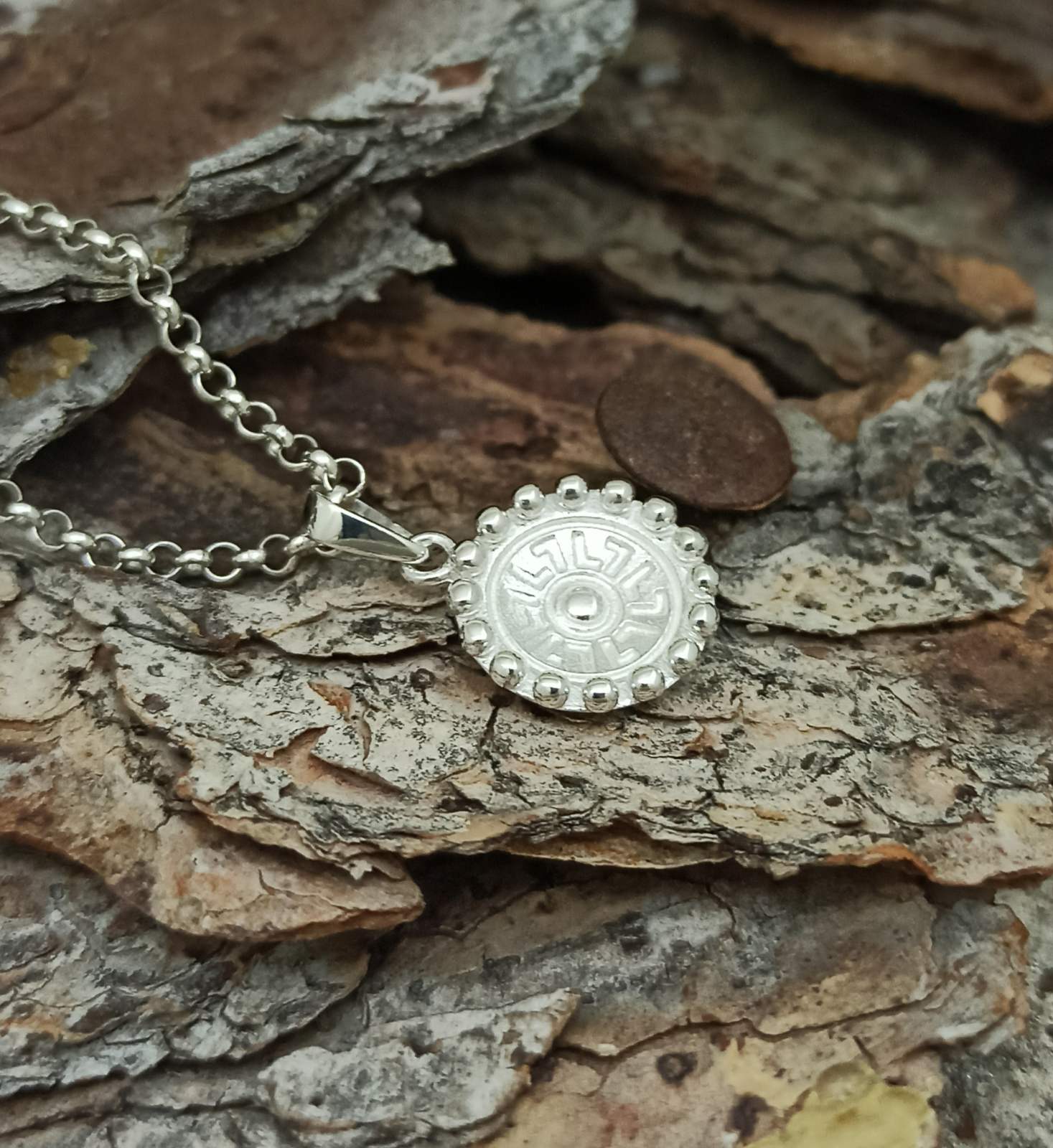 Дамски сребърен медальон с основен елемент вдлъбнат кръг с орнаменти без оксидация на среброто. Модел с каталожен номер 1588M