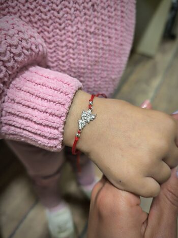 Гривна с червен конец и сребърно ангелче – защита и благословия